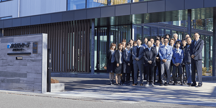 Photo of the company’s staff in front of the main entrance