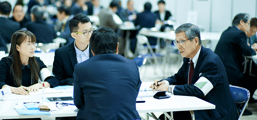 日本企業と海外企業の間に座って商談をサポートする植田コーディネーター